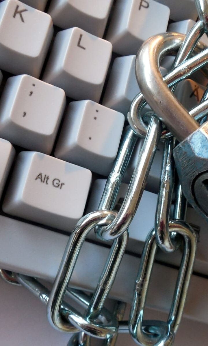 Una tastiera per computer legata da una catena di ferro con un lucchetto chiuso